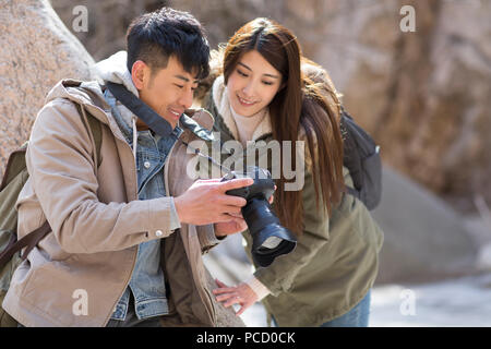 Happy young Chinese couple photographing outdoors in winter Stock Photo