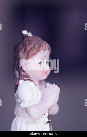 Cake topper Catholic holy communion ceremony religious girl praying to Christian God in church. Stock Photo
