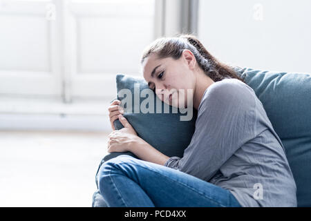 Young attractive latin woman lying at home living room couch feeling sad tired and worried suffering depression in mental health, problems and broken  Stock Photo