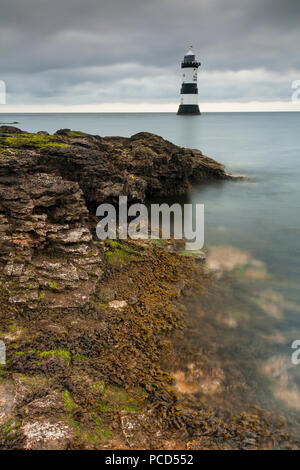 Lighthouse at Penmon Point under clouds, Anglesey, North Wales Stock Photo
