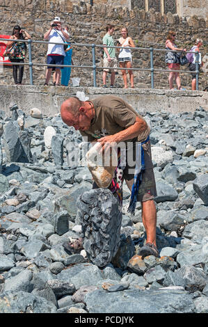 man stone stacking on the beach in st.ives, cornwall, england, britain, uk. Stock Photo