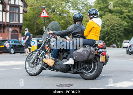Person with pillion passenger riding a Harley-Davidson Bike FXSTBI Softail Night Train motorbike from 2004 in West Sussex, England, UK. Stock Photo