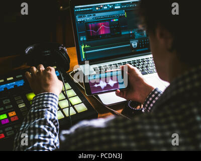 close up sound producer's hand holding phone and using app to create music  in sound recording studio Stock Photo - Alamy