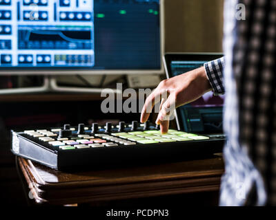 close up man's hand recording sound in recording music studio using new modern equipment with large monitor and laptop Stock Photo
