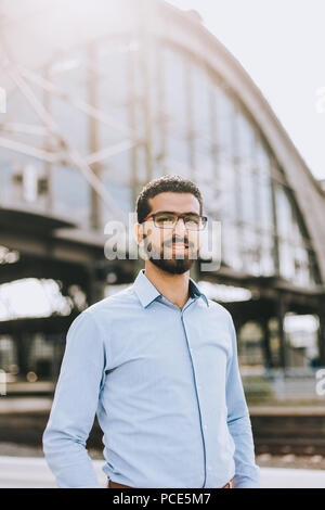 Portrait of handsome and cheerful syrian man at the train station Stock Photo