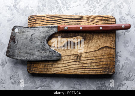 Old rustic axe for meat on a wooden board Stock Photo