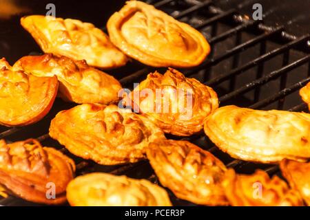 Oscypek - traditional smoked cheese made of salted sheep milk on a grill. Traditional Polish smoked cheese made of sheep milk known as oscypek on barb Stock Photo