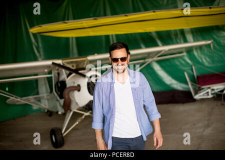 Handsome young pilot checking ultralight airplane before flight Stock Photo