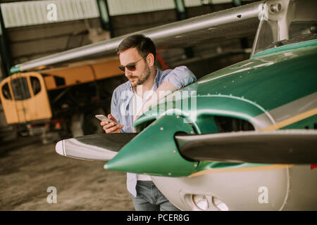 Handsome young pilot checking ultralight airplane before flight Stock Photo