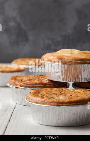 Upright image of meat pies in tin foil cases Stock Photo