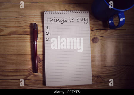 Notebook on the table with words written on one page with pen and coffee mug on both sides Stock Photo