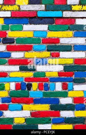 Colorful brick wall background. Rainbow colourful brick wall. Colorful brick wall pattern, painted bricks as urban design texture. Stock Photo