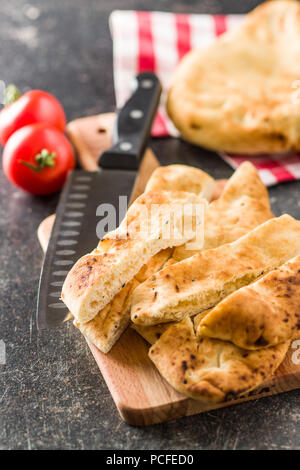 Indian naan bread on old kitchen table. Stock Photo