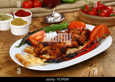 Skewers of grilled chicken on plate with garnish Stock Photo