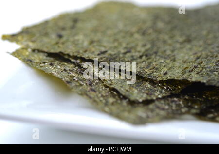 Detail top view of dried seaweed: nori. Isolated on white.Nutrient rich vegan, raw and healthy sea vegetables. Stock Photo