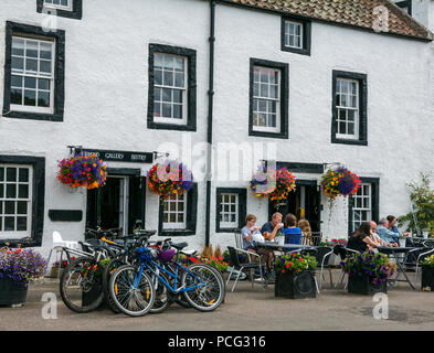 Cramond, Edinburgh, Scotland, United Kingdom, 2nd August 2018. People enjoying refreshments on the pavement tables outside Cramond Gallery Bistro with bicycles parked nearby Stock Photo