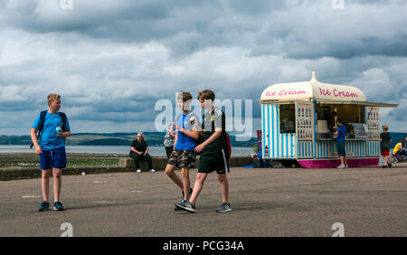 Cramond, Edinburgh, Scotland, United Kingdom, 2nd August 2018. Boys walking with ice cream cones from Fotheringham's ice cream stall on a sunny Summer day at the coast in the village Stock Photo