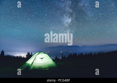 Green tent lighted from the inside Stock Photo