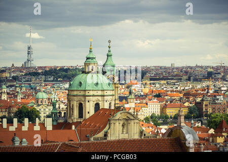 Elevated view over the rooftops and cityscape of Prague on a stormy day. Shows the architecture inc St Nicholas Church and Žižkov Television Tower. Stock Photo