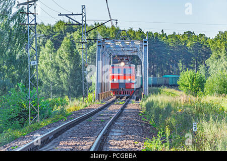 Long freight train moves through the bridge. Stock Photo