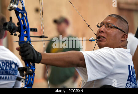 JOINT BASE PEARL HARBOR-HICKAM, Hawaii (Nov. 14, 2012) Retired Boatswain's Mate 1st Class Jim Castaneda, wounded warrior, draws a bow with his mouth during archery practice during the Wounded Warrior Pacific Trials. Castaneda suffered a heart stroke and is unable to use the right side of his body. Wounded, ill and injured Sailors and Coast Guardsman from across the country are going head-to-head in archery, cycling, track and field, shooting, sitting volleyball, swimming, and wheelchair basketball for one of 35 places on the 2013 Warrior Games Navy-Coast Guard team. Stock Photo