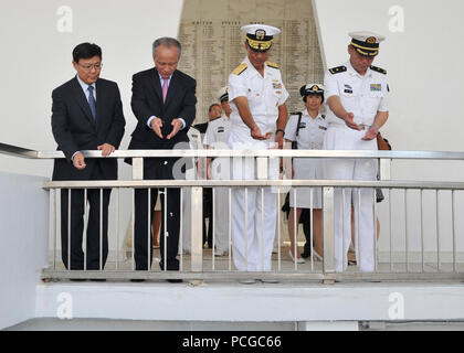 PEARL HARBOR (Sept. 6, 2013) Liu Jian, left, the Consul-General, Los Angeles, of the PeopleХs Republic of China,  China's ambassador to the United States Cui Tiankai, Adm. Cecil D. Haney, commander of U.S. Pacific Fleet, and Rear. Adm. Wei Gang, chief of staff for North Sea Fleet, throw flowers into the wishing well aboard the USS Arizona Memorial during a tour of historic Pearl Harbor sites. Haney hosted Ambassador Cui and his delegation in conjunction with the ongoing port visit to Pearl Harbor by three Chinese navy ships. Stock Photo