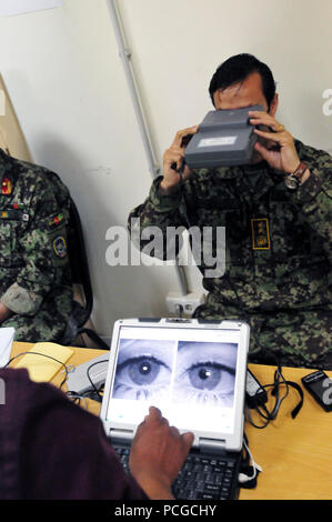 KABUL, Afghanistan -- Maj. Gen. Abdul Sabour, Director of INtelligence for the Afghan National Air Force participates in biometric data collection of his personal history, iris scan, thumb print, and urinalysis under a new accountability program in the Afghan Air Force. (US Navy Stock Photo