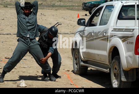 KABUL, Afghanistan (April 20, 2010) – An Afghan National Civil Order Police (ANCOP), Non-Commissioned Officer, checks a driver who was “taken into custody” for weapons, during traffic control point training at a Kabul facility.  Members of the elite police force received training in traffic control and communications gear as they prepare for operations in Afghanistan. (US Navy Stock Photo