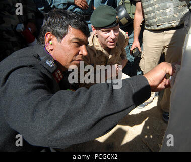 Afghan Maj. Gen. Sharif, left, commander Afghan National Civil Order Police, left, and Canadian Maj. Gen. Mike Ward, deputy commander NATO Training Mission - Afghanistan, check out their shot patterns after participating in an ANCOP weapons training exercise at a Kabul facility. The police officers of the elite, ANCOP force received convoy training and marksmanship training as they prepare for operations in Afghanistan. NTM-A is responsible for training and transitioning the sustainability of the Afghan National Army and Police forces. Stock Photo