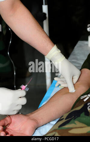 An Afghan National Army soldier participating in the Combat Medic course being taught at the National Military Hospital practices administering an IV on a fellow classmate April 6, 2010. The Afghan-led Combat Medic course is one of several specialized schools that ANA soldiers may attend after graduating from Kabul Military Training Center. Stock Photo