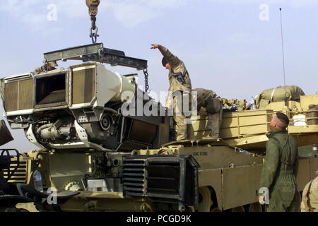 Marines from 1st Tank Battalion, Twentynine Palms, California, load a Honeywell AGT 1500 gas turbine engine an M1A1 Abrams tank engine back into the tank at Camp Coyote, Kuwait during Operation ENDURING FREEDOM. Stock Photo