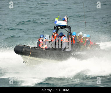 Members of a visit, board, search and seizure team assigned to the U.S. Coast Guard cutter Mohawk, and a law enforcement detachment made up of members of the Sierra Leone Armed Forces, make their way toward Mohawk on an rigid-hull inflatable boat after conducting a search of two vessels suspected of conducting illegal activities. Mohawk recently participated in the African Maritime Law Enforcement Partnership. Stock Photo