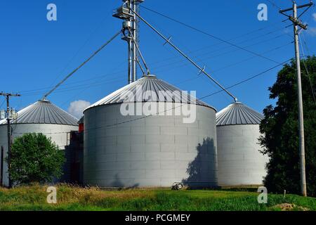 Creston, Illinois, USA. Metal crop storage tanks make up a farmers cooperative in rural northeastern Illinois. Stock Photo