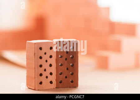 Low angle view on two sharp-pointed toy bricks in the foreground and bricks corner in the blurry background. Stock Photo