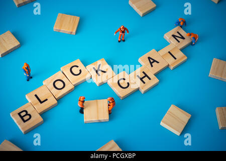 Workers arranging wood with text Blockchain. Stock Photo
