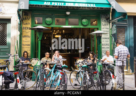 Paris cafe Au Petit Fer a Cheval - Patrons enjoying morning coffee at the cafe Au Petit Fer a Cheval with bicycles parked in front, France, Europe. Stock Photo