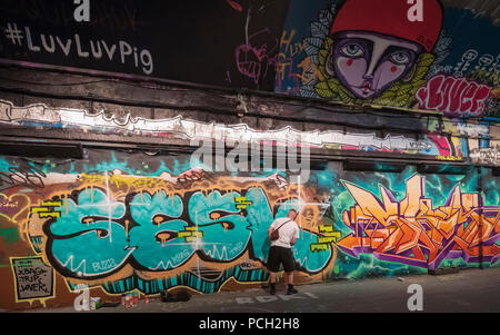 graffiti artist spraying graffiti on wall in London Stock Photo