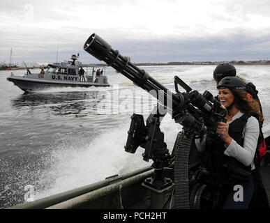 PORTSMOUTH, Va. (Dec. 7, 2012) Eve, a World Wrestling Entertainment (WWE) diva, holds a .50-caliber machine gun aboard a Riverine Patrol Boat during a WWE tour of Coastal Riverine Force capabilities. WWE athletes visited Coastal Riverine Group 2 as part of the 10th annual WWE 'Tribute to the Troops' in Hampton Roads. Stock Photo