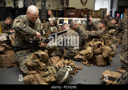 ATLANTIC OCEAN (Jan. 28, 2013) A Marine assigned to the 26th Marine Expeditionary Unit (26th MEU) cleans his weapon during a raid drill aboard the amphibious assault ship USS Kearsarge (LHD 3). Kearsarge is participating in Composite Training Unit Exercise (COMPTUEX) off the East Coast of the United States in preparation for an upcoming deployment this spring. Stock Photo