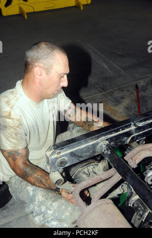 GUANTANAMO BAY, Cuba – Army Spc. Joseph Pine repairs a shock absorber on a Gator 4-by-4 vehicle, May 18, 2010. JTF Guantanamo conducts safe, humane, legal and transparent care and custody of detainees, including those convicted by military commission and those ordered released by a court. The JTF conducts intelligence collection, analysis and dissemination for the protection of detainees and personnel working in JTF Guantanamo facilities and in support of the War on Terror. JTF Guantanamo provides support to the Office of Military Commissions, to law enforcement and to war crimes investigation Stock Photo