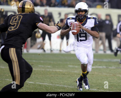 PHILADELPHIA (Dec. 8, 2012) U.S. Naval Academy quarterback Keenan Reynolds ges an Army defender during the 113th Army-Navy Football game at Lincoln Financial Field. The winner of the game will take home the Commander in Chief's Trophy, which is presented annually to the winner of the football competition among the service academies. Navy has won the last ten meetings between the two teams. Stock Photo
