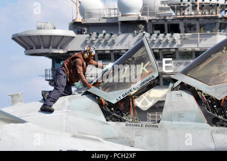 ARABIAN SEA (Nov. 25, 2012) Airman Jay Abraham, assigned to the Patriots of Electronic Attack Squadron (VAQ) 140, cleans the canopy of an EA-6B Prowler on the flight deck  aboard the Nimitz-class aircraft carrier USS Dwight D. Eisenhower (CVN 69). Dwight D. Eisenhower is deployed to the U.S. 5th Fleet area of responsibility conducting maritime security operations, theater security cooperation efforts and support mission as part of Operation Enduring Freedom. Stock Photo