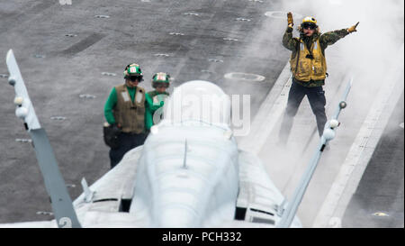 PACIFIC OCEAN (June 15, 2015) A Sailor directs an F/A-18C Hornet attached to the Gladiators of Strike Fighter Squadron (VFA) 106 for launch from the aircraft carrier USS John C. Stennis (CVN 74). John C. Stennis is undergoing an operational training period in preparation for future deployments. Stock Photo