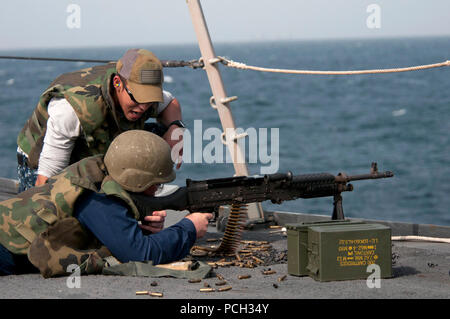 U.S. 5TH FLEET AREA OF RESPONSIBILITY (Jan. 9, 2013) Gunner's Mate 2nd Class Carlos A. Rentas, from Peneulas, Puerto Rico, directs a Sailor firing an M240B machine gun during a live-fire weapons qualification aboard the guided-missile destroyer USS Winston S. Churchill (DDG 81). Winston S. Churchill is deployed with the John C. Stennis Carrier Strike Group to the U.S. 5th Fleet area of responsibility conducting maritime security operations, theater security cooperation efforts and support missions for Operation Enduring Freedom. Stock Photo