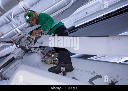 ATLANTIC OCEAN (Jan. 24, 2013) Aviation Machinist’s Mate 1st Class Jeffery Manuel cleans and inspects the tail rotor of an MH-60R Sea Hawk helicopter assigned to the Swamp Foxes of Helicopter Maritime Strike Squadron (HSM) 74 aboard the aircraft carrier USS Harry S. Truman (CVN 75). Harry S. Truman is underway conducting a composite training unit exercise in preparation for its upcoming deployment. Stock Photo