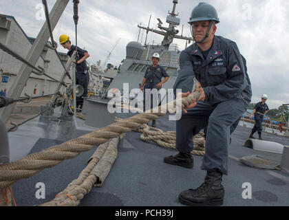 SEMBAWANG, Singapore (Feb. 19, 2015) Culinary Specialist 1st Class Robert Parks, from Fostoria, Ohio, heaves a mooring line on the forecastle of the littoral combat ship USS Fort Worth (LCS 3) during a sea and anchor detail.  Fort Worth is on a 16-month rotational deployment in support of the Asia-Pacific Rebalance, Stock Photo