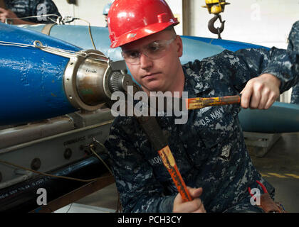 NAVAL WEAPONS STATION SEAL BEACH, Calif. (Jan 17, 2013) Mineman 2nd Class Daniel P. Cadigan runs arming wires to a practice mine at Naval Weapons Station Seal Beach. Navy Munitions Command CONUS West Division, Unit Seal Beach, Underwater Weapons Department personnel practice building mines from inert general purpose bombs. Stock Photo