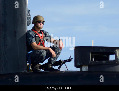 DIEGO GARCIA (Dec. 4, 2013) Fire Control Technician 2nd Class Nathan Bownas, assigned to the Los Angeles-class fast attack submarine USS Scranton (SSN 756), provides security to the boat as it pulls into U.S. Navy Support Facility Diego Garcia. Stock Photo