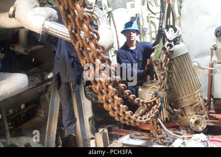 SULU SEA (March 21, 2013) Navy Diver 2nd Class Matthew Costa, assigned to Mobile Diving and Salvage Unit (MDSU) 1, guides a piece of equipment being lifted from the engine room compartment of the Avenger-class mine countermeasures ship ex-Guardian (MCM 5). Guardian ran aground on the Tubbataha Reef.  The U.S. Navy continues to work in close cooperation with Philippine authorities to safely dismantle Guardian from the reef while minimizing environmental effects. Stock Photo