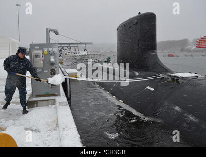 GROTON, Conn. (Feb. 8, 2013) Sailors assigned to the Virginia-class attack submarine USS Missouri (SSN 780) shovel the initial blanket of snow from their pier as a strong nor'easter arrives in Connecticut. Stock Photo